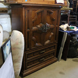 Antique wooden Bassett armoire with intricate carvings and storage compartments