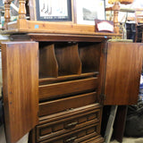 Antique wooden Bassett armoire with intricate carvings and storage compartments