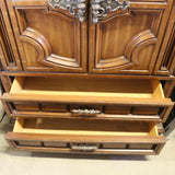Antique wooden Bassett armoire with intricate carvings and storage compartments