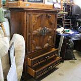 Antique wooden Bassett armoire with intricate carvings and storage compartments