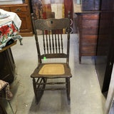 Antique oak rocking chair with caned seat and pressed back detailing
