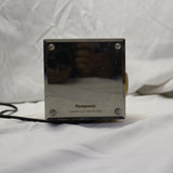 Vintage Panasonic cube clock radio with mirrored display and rotary dials, showing wear and tear.