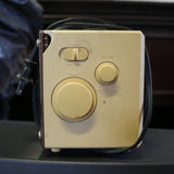 Vintage Panasonic cube clock radio with mirrored display and rotary dials, showing wear and tear.